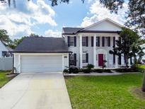 Charming two-story home featuring a two-car garage, well-manicured lawn, and elegant architectural details at 2619 Green Valley St, Valrico, FL 33596