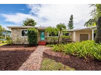Charming single-story home featuring a stone facade, well-manicured landscaping, and a brick pathway at 3321 14Th N St, St Petersburg, FL 33704