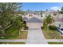 Charming two-story home with a well-manicured lawn and a two car garage, and mature trees at 3351 Lintower Dr, Land O Lakes, FL 34638