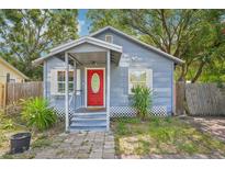 Charming single-story home featuring a bright red front door and inviting front porch at 4801 71St N St, St Petersburg, FL 33709