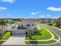 Two-story home showcasing a well-manicured lawn and a three car garage at 4805 Holdsworth Dr, Land O Lakes, FL 34639