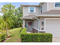 Charming two-story home featuring a gray front door with a festive wreath and well-manicured landscaping at 5332 Riverwalk Preserve Dr, New Port Richey, FL 34653