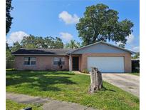 Charming brick home with a well-maintained lawn and mature tree at 603 Southwood Cv, Brandon, FL 33511