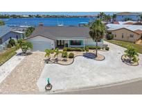 Inviting single-story waterfront home featuring lush landscaping, a brick driveway, and breathtaking ocean views at 6322 Cocoa Ln, Apollo Beach, FL 33572