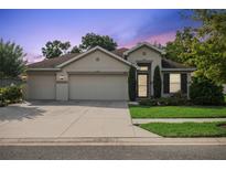 Charming single-story home with a three-car garage and well-manicured lawn at 6555 Sparkling Way, Wesley Chapel, FL 33545