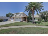 Charming two-story home featuring a well-manicured lawn, mature landscaping, and a spacious two-car garage at 7600 Drew Oak Dr, Seminole, FL 33772