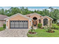 Charming single-story home featuring a brick driveway, well-manicured lawn, and an attached two-car garage at 9735 Conservation Dr, New Port Richey, FL 34655
