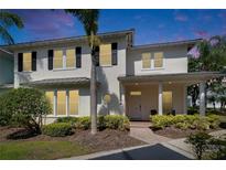 Charming two-story home with a welcoming front porch and meticulously landscaped yard. Brick path, palm trees, and fresh exterior paint at 110 Aberdeen Pond Dr, Apollo Beach, FL 33572