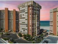 A high-rise condo building overlooks the ocean with lush landscaping and plenty of parking spaces at 17920 Gulf Blvd # 208, Redington Shores, FL 33708