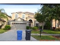 Two-story home with a two-car garage, complemented by a well-maintained lawn and a welcoming front entrance at 20420 Carolina Cherry Ct, Tampa, FL 33647