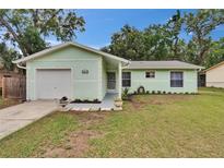 Charming single-story home with a well-maintained lawn, inviting entrance, and attached garage at 2415 Devonwoode Pl, Seffner, FL 33584