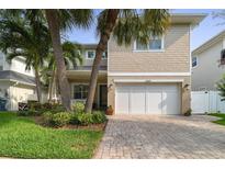 Charming two-story home boasts a large garage, brick driveway and lush landscaping with mature palm trees at 3109 W Granada St, Tampa, FL 33629