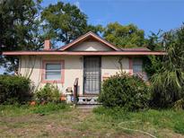 Charming single-story home with a secure metal door and a lush garden surrounding the front entrance at 3706 N 36Th St, Tampa, FL 33610