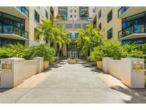 Inviting condominium building entrance with lush tropical landscaping and water feature at 400 4Th S Ave # 508, St Petersburg, FL 33701