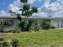 Exterior view of home, landscape, and driveway, with partially cloudy sky at 5991 42Nd N Ave, St Petersburg, FL 33709