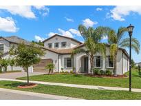 Charming white two-story home featuring a beautiful landscaped yard, tile roof, and two-car garage at 6154 Marsh Trail Dr, Odessa, FL 33556