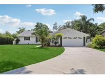 Charming single-story home featuring a well-manicured lawn, a two-car garage and beautiful curb appeal at 71 Flamingo Cir, Safety Harbor, FL 34695