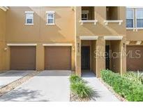 Townhouse with neutral paint, two-car garage, small yard with walkway leading to entry at 9013 White Sage Loop, Lakewood Ranch, FL 34202