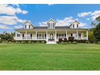 Charming home with a large front porch, manicured lawn and beautiful landscaping at 9830 Caribou Trl, Dade City, FL 33525