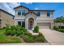 Charming two-story home featuring a manicured lawn and an attached two-car garage at 12650 Shetland Walk Dr, Lithia, FL 33547