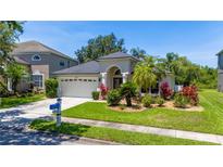 Charming single-story home featuring a well-manicured lawn and beautiful landscaping at 19412 Heritage Harbor, Lutz, FL 33558