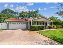 Charming single-story home with a red tile roof, brick driveway, and a well-manicured front yard at 2484 Whitman St, Clearwater, FL 33765