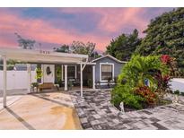 Charming single-story home featuring a welcoming front porch, colorful landscaping, and a covered parking area at 3414 Whittier St, Tampa, FL 33619