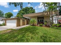 Modern home featuring a well-manicured lawn and a stylish contemporary design with a side-entry two car garage at 4304 N River View Ave, Tampa, FL 33607