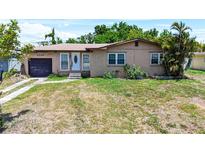 Cozy single-story home featuring a front lawn and a one-car garage, with mature trees for added privacy at 4709 Mineola St, Bradenton, FL 34207