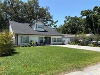 Charming home featuring a well-manicured lawn, a quaint porch, and an inviting exterior at 4710 W Tambay Ave, Tampa, FL 33611