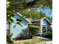 Charming home featuring a mix of blue siding and brick, complemented by lush greenery and mature trees at 5804 Red Cedar Ln # 5804, Tampa, FL 33625