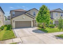 Charming two-story home features a two-car garage, manicured lawn, and inviting curb appeal at 7211 Ronnie Gardens Ct, Tampa, FL 33619