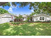 Charming single-story home with a well-manicured lawn and mature landscaping at 10513 Carrollview Dr, Tampa, FL 33618