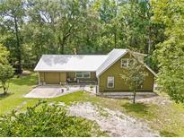 Charming home with a metal roof, a quaint front yard and a wooded setting at 1562 Oakhurst Dr, Brooksville, FL 34601
