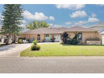 Charming single-story home features a well-manicured lawn and inviting front porch seating area at 1913 Libby Ct, Holiday, FL 34690