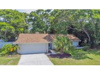 Charming single-story home featuring a well-maintained yard and attached two-car garage at 2285 Hidden Meadows E Dr, Palm Harbor, FL 34683