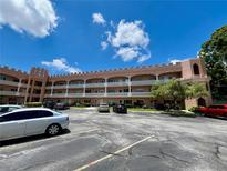 A spacious condo exterior view with a well-maintained parking lot and balconies on each level at 2457 Ecuadorian Way # 27, Clearwater, FL 33763