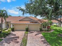 Charming villa with a red brick driveway, two-car garage, and well-maintained landscaping at 2516 New Haven Cir, Sun City Center, FL 33573