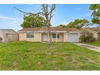 Charming single-story home with a front yard and attached garage, perfect for a starter home at 3559 Rock Royal Dr, Holiday, FL 34691