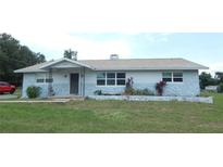 Charming single-story home featuring a stone facade, well-maintained lawn, and a welcoming front entrance at 38535 Clinton Ave, Dade City, FL 33525
