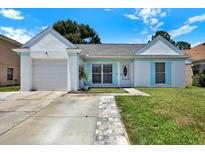 Charming single-story home featuring a well-manicured lawn, inviting entryway, and attached garage at 4307 Shadberry Dr, Tampa, FL 33624
