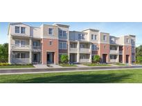 A modern townhome row with red brick and gray accents showcases stylish architecture and manicured landscaping at 4511 S Manhattan Ave # 3, Tampa, FL 33611
