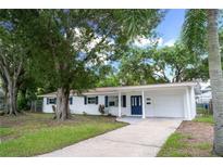 Charming single-story home featuring white siding, a blue front door, and a well-maintained front yard at 4650 32Nd N Ave, St Petersburg, FL 33713