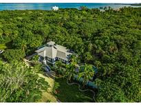 Stunning aerial view of the property showcasing lush landscaping, pool, and architectural details at 540 Gulf Bay Rd, Longboat Key, FL 34228