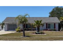 Charming single-story home with a well-manicured lawn, complemented by vibrant landscaping and curb appeal at 6405 Klaus Ct, Port Charlotte, FL 33981