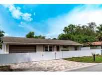 Charming single-story home with a brick driveway, well manicured lawn, and a fenced yard at 6423 Boxwood St, Brooksville, FL 34602