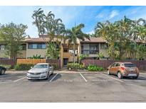 Inviting two-story condo with tropical landscaping, reserved parking, and a charming fence for added curb appeal at 775 N Village N Dr # 106, St Petersburg, FL 33716