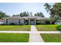 Charming single-story home featuring a well-manicured lawn and inviting entryway at 9908 Alafia River Ln, Gibsonton, FL 33534