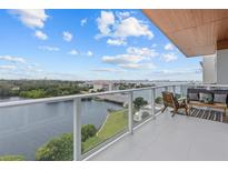 Enjoy a breathtaking waterfront view from this luxury balcony with comfortable seating and privacy glass railing at 1020 Sunset Point Rd # 712, Clearwater, FL 33755