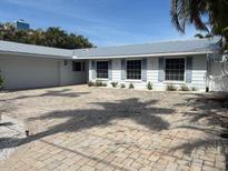 Charming single-story home with a neutral color palette and a spacious brick driveway at 12055 4Th E St, Treasure Island, FL 33706